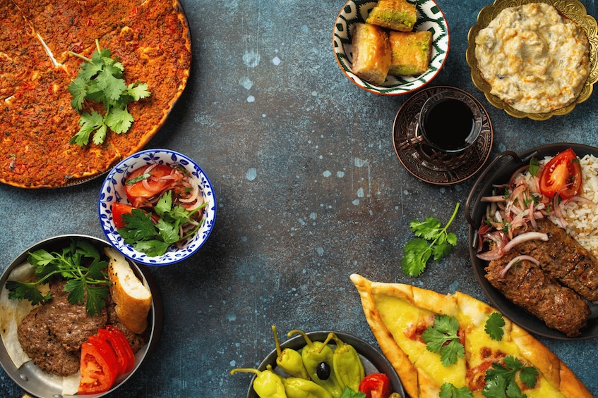A variety of dishes including a large pie, stuffed vegetables, and meat kebabs. 3