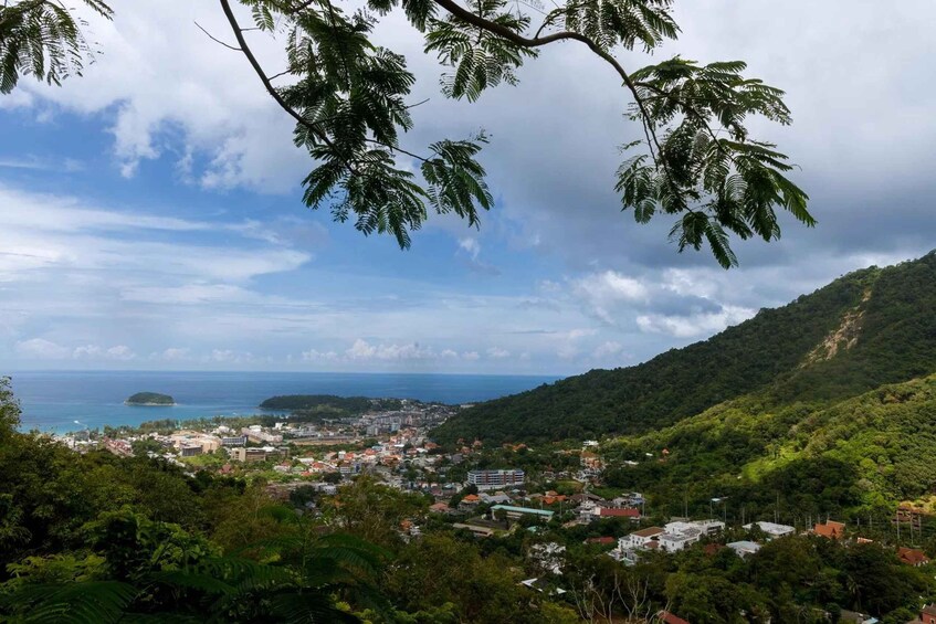 A coastal town nestled in a valley with a view of the sea and a distant island. 2