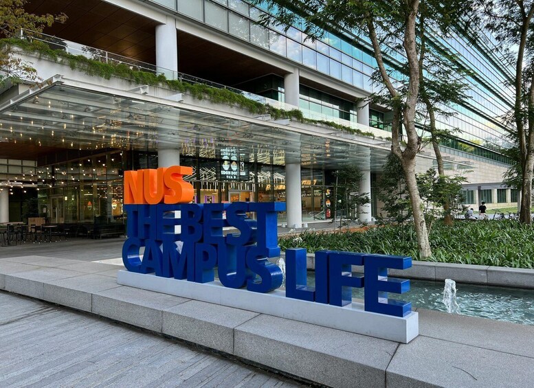 A modern building with a glass facade and a sign that reads 'MUS THE BEST CAMPUS LIFE.' 2