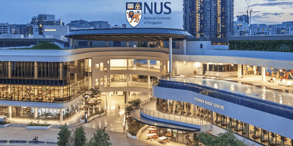 A modern building with a curved facade, a prominent logo, and the name 'Stephen Riady Centre' on the lower part. 1