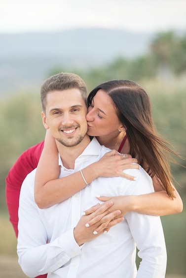 A couple embracing in a field with a blurred natural background. 3
