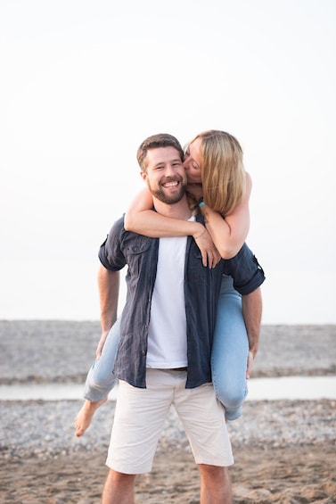 A person carrying another on their shoulders on a beach. 4