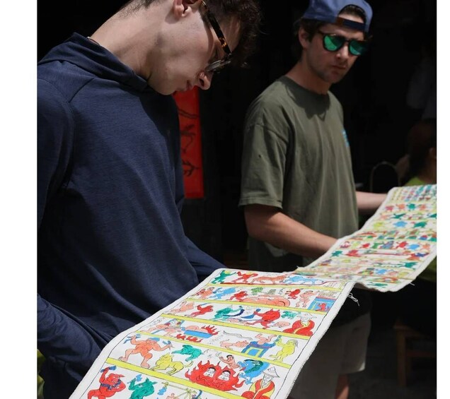 Two individuals examining a colorful map with illustrations. 5