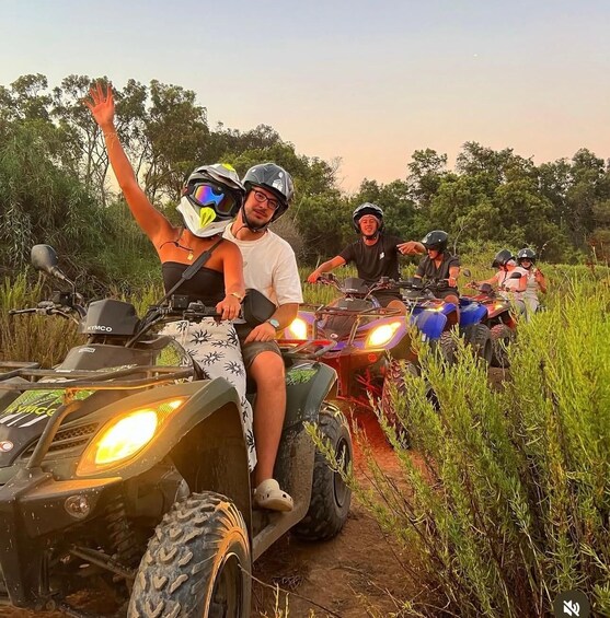 A group of people on ATVs in a grassy area with trees in the background. 3