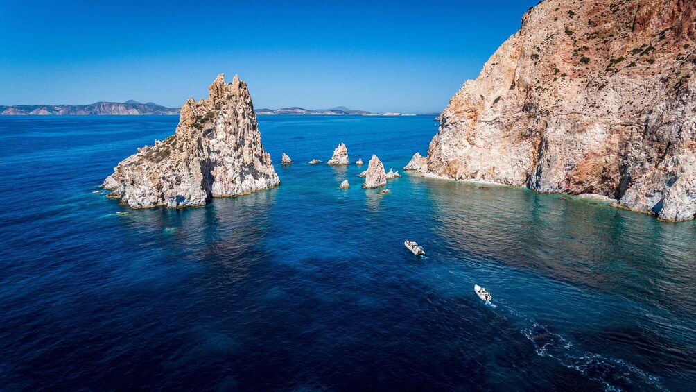 A coastal landscape with rocky formations and clear blue waters. 4