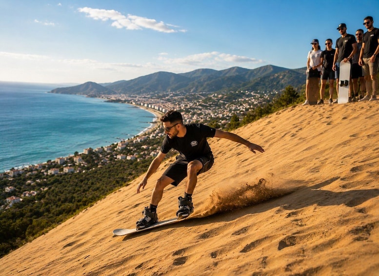 A person snowboarding down a sandy slope with a coastal town in the background. 3