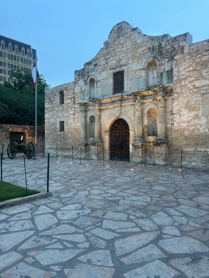 A historic stone building with an ornate archway and a flagpole. 1