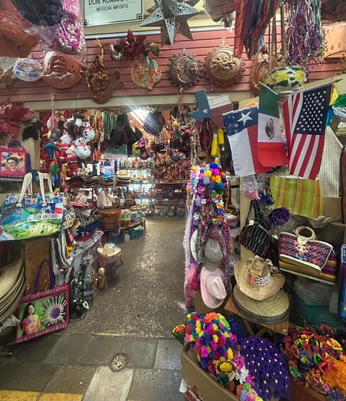 A vibrant market with various stalls selling handicrafts, including colorful woven items and decorative masks. 3