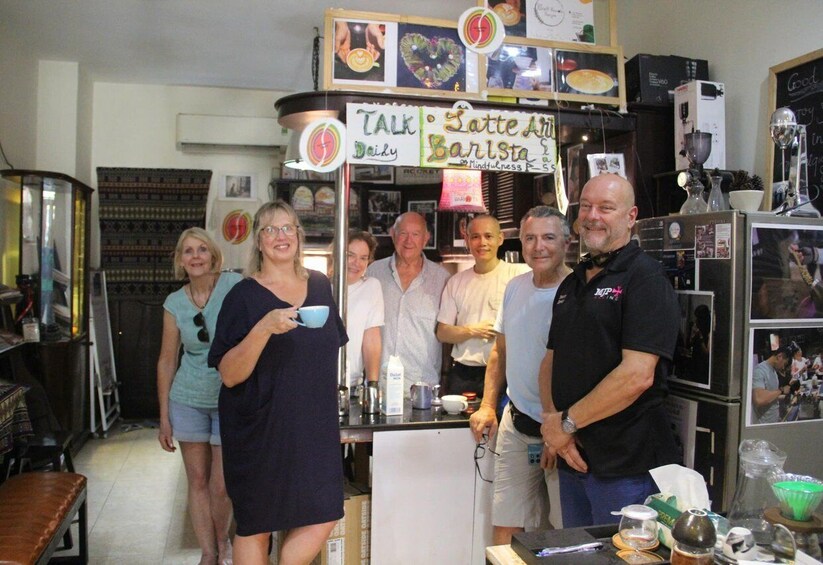 A group of people in a cafe with a sign that reads 'Talk Daily Barista.' 4