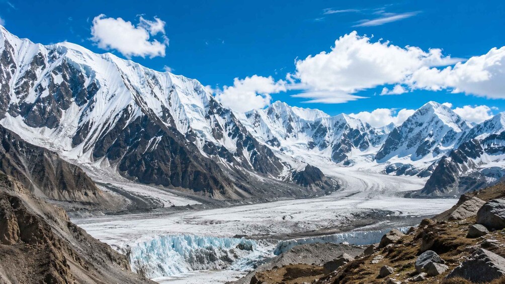 A glacier valley with snow-covered mountains and a clear blue sky. 2