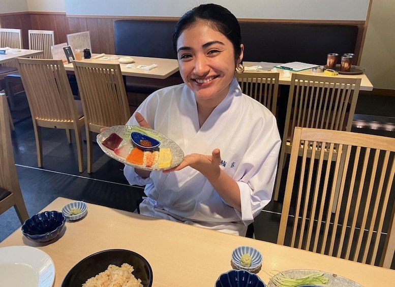 A person holding a plate with various sashimi and wasabi. 3