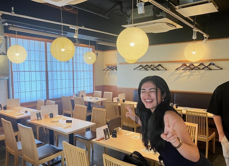 A restaurant interior with wooden tables, chairs, and hanging spherical light fixtures. 2