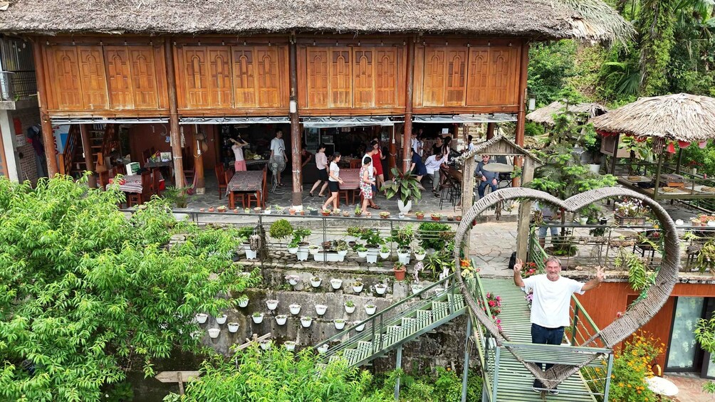 A traditional wooden building with a thatched roof, surrounded by lush greenery and potted plants. 4