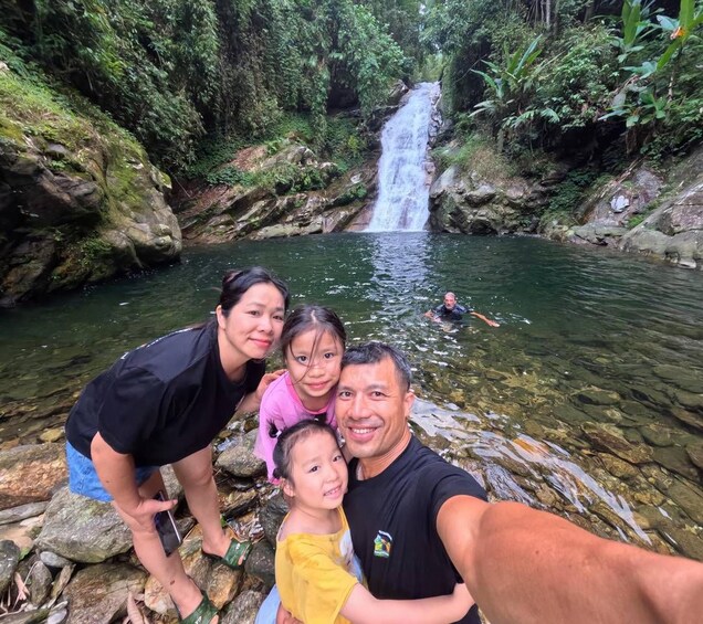 A waterfall, a group of people, and a clear river. 1