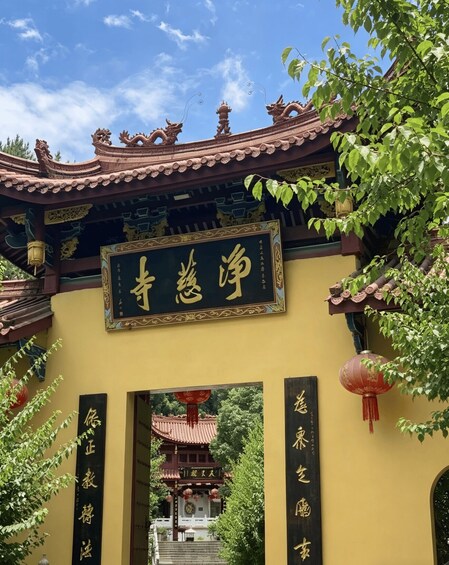 A traditional Chinese gate with ornate dragon sculptures and a signboard with Chinese characters. 3
