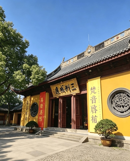 A traditional building with a yellow facade, a red entrance, and Chinese characters. 5