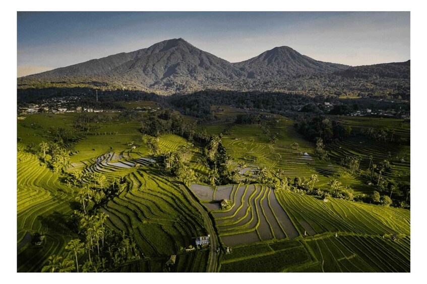 Terraced rice fields, a mountain, and a small settlement. 3