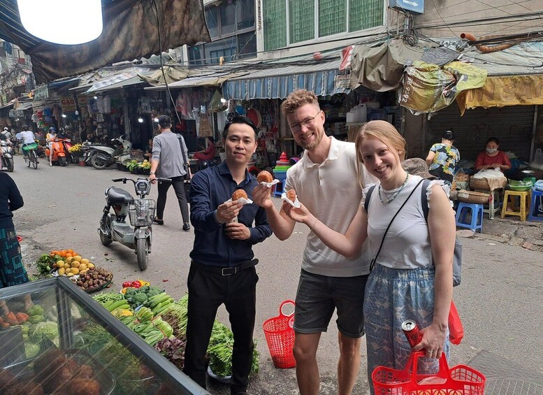 A street market with people shopping and vendors selling goods. 3