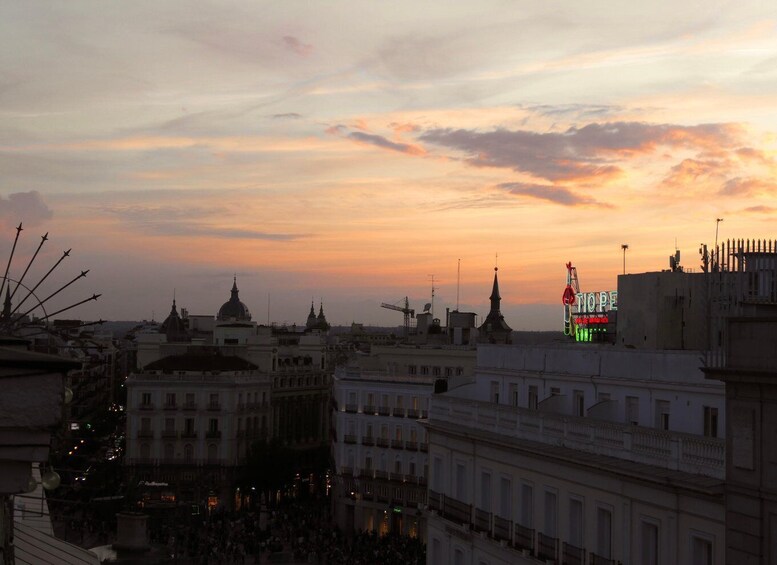 A cityscape at sunset with illuminated buildings and a prominent 'HOPE' sign. 2