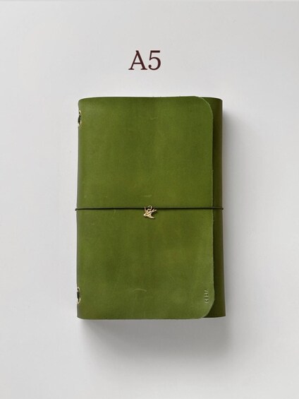 A green notebook with a ribbon bookmark and the label 'A5' on a white background. 1