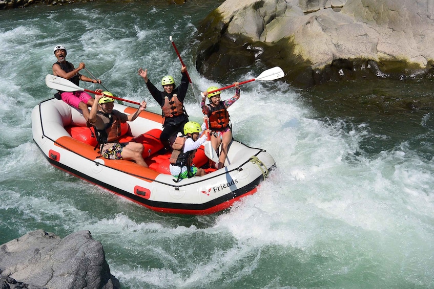 A group of people rafting on a river with rapids. 1