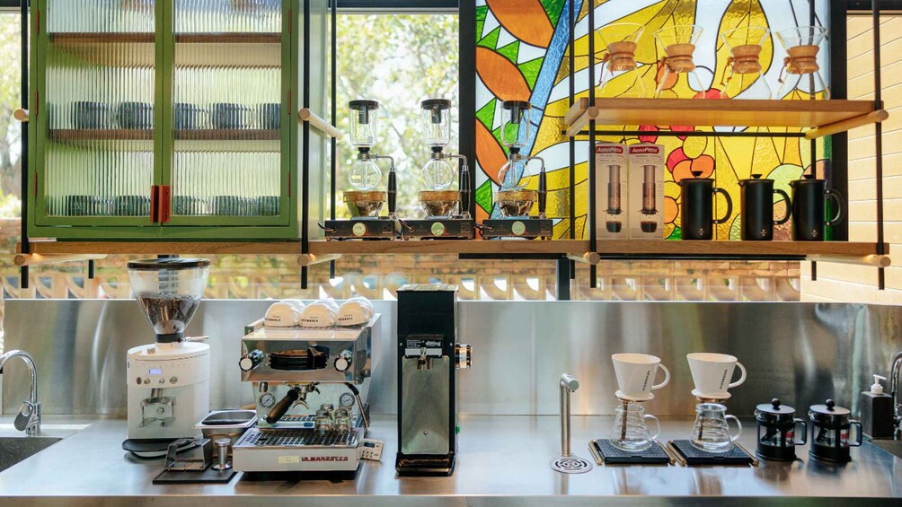 A coffee shop with espresso machines, coffee cups, and a colorful stained glass window. 2
