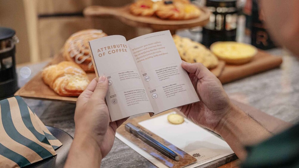 A person reading a book titled 'ATTRIBUTES OF COFFEE' with pastries and coffee in the background. 3