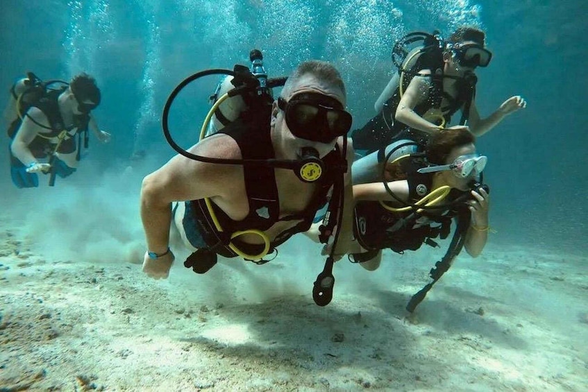 Scuba divers underwater with fins and tanks. 2