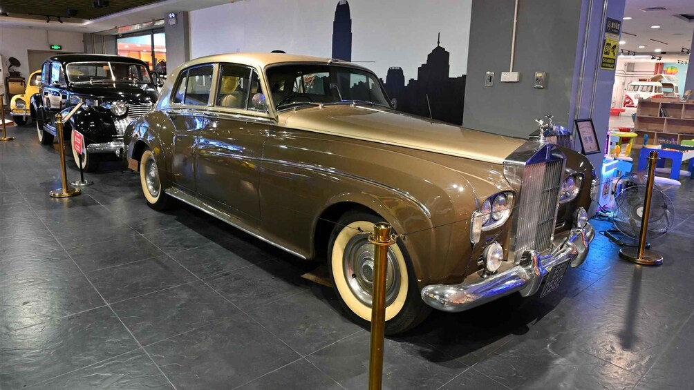 A vintage car on display in an indoor exhibition with other classic cars. 5