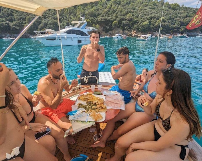 A group of people on a boat with food and drinks, surrounded by water and boats. 2