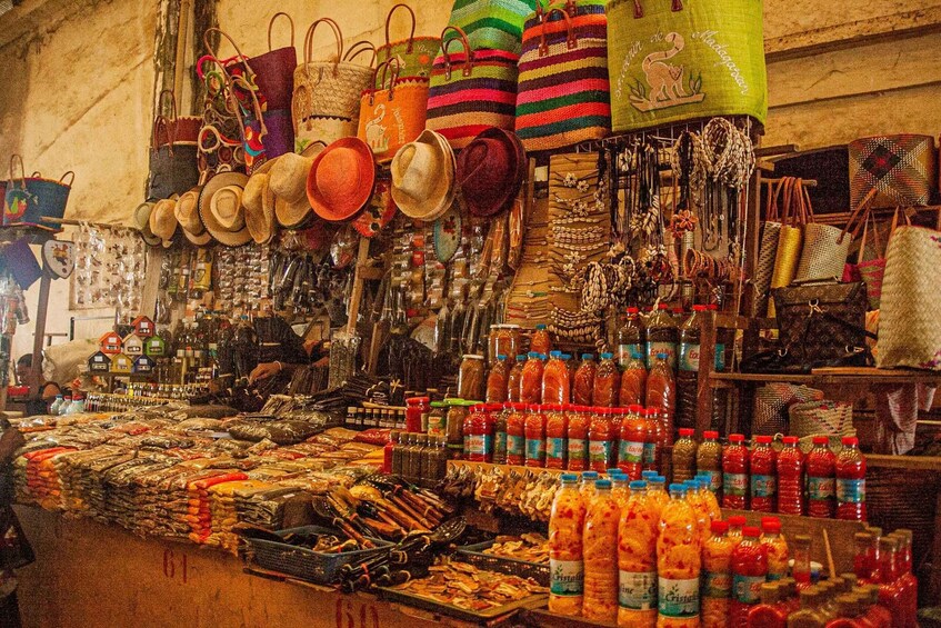 A market stall with bags, hats, and bottled drinks. 3