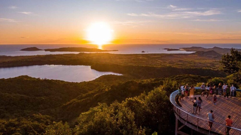 A sunset over a lake with a viewing platform and people observing. 1
