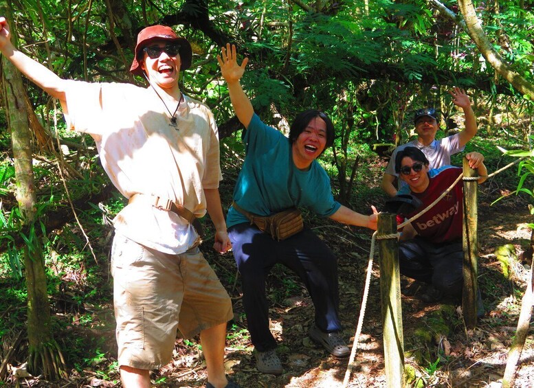 A group of people hiking in a forested area with dense foliage and trees. 4
