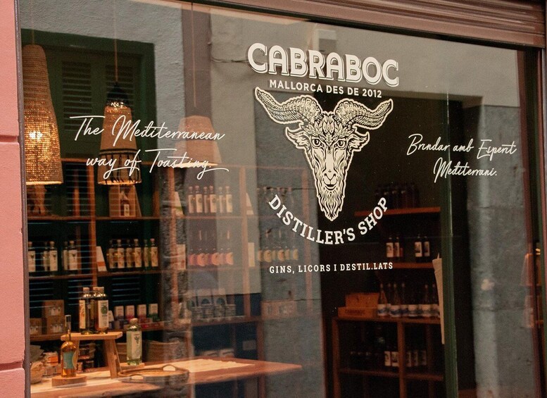 A distillery shop window with a bull's head logo, shelves of bottles, and the text 'CABRABOC MALORCA DES DE 2012'. 3