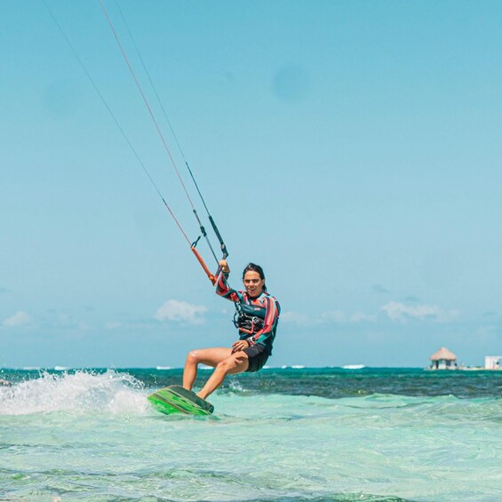 A person kiteboarding on clear turquoise waters with a clear sky. 4