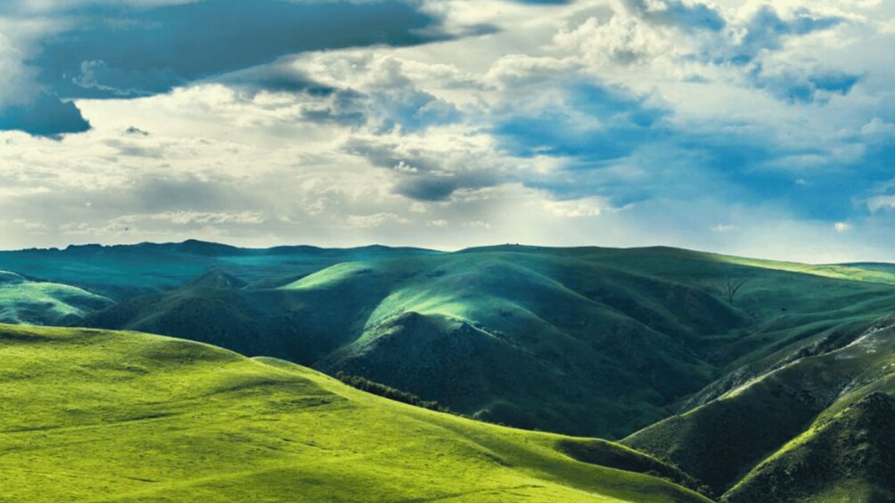 Rolling green hills under a cloudy sky. 4