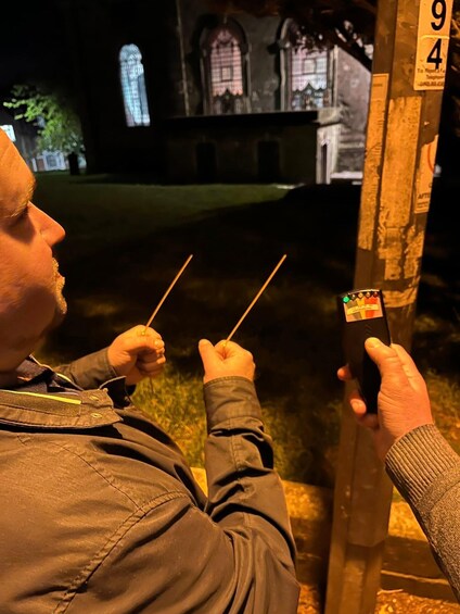 A person holding two sticks, looking at a sign with the numbers 94 and 9. 3