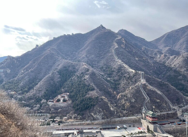 A mountainous landscape with a winding road, traditional buildings, and a large pagoda. 4