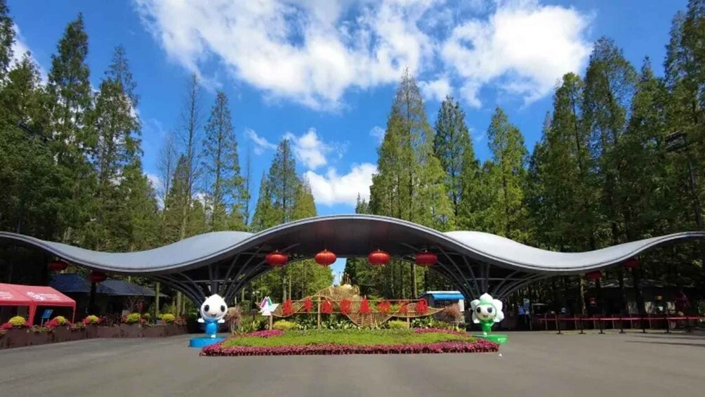 A park with a curved roof structure, red lanterns, and a central statue. 4