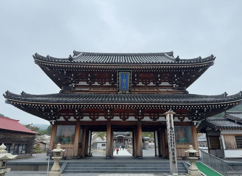 A traditional Japanese gate with multiple tiers and a blue sign. 3