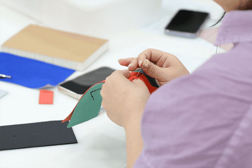 A person sewing a patch onto a piece of fabric. 2