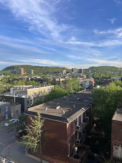 A cityscape with buildings, a clear sky, and a hill in the background. 3