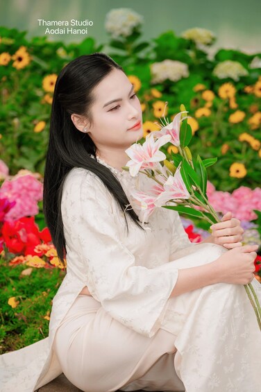 A person in a white dress holding flowers, surrounded by a variety of colorful flowers. 2