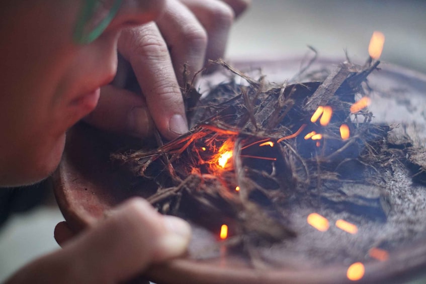 A person holding a fire with glowing embers. 5