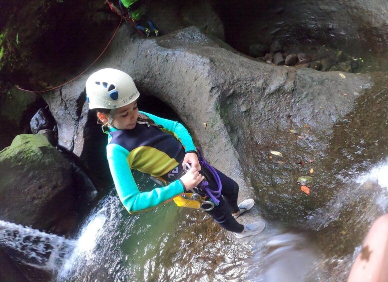 A person rappelling down a rocky waterfall. 2