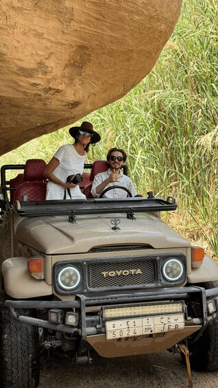 A Toyota off-road vehicle with a large rock on its roof, parked in a grassy area. 5