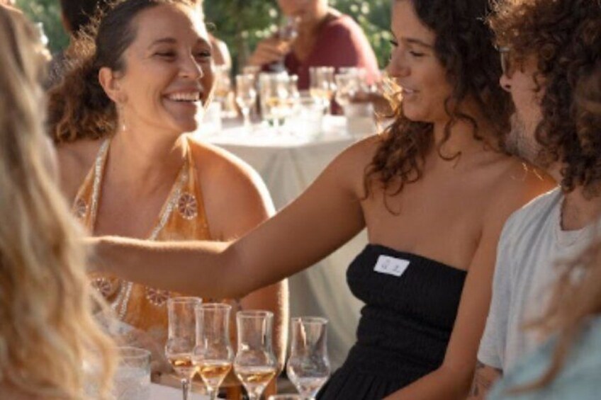 A group of people sitting at a table with wine glasses. 1