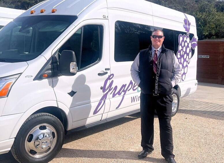 Valkoinen pakettiauto, jonka kyljessä on teksti »Grapes Wine», oli pysäköitynä sorapintaiselle alueelle. 2