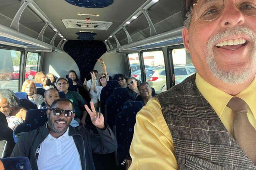 A bus interior with passengers, some making peace signs. 3