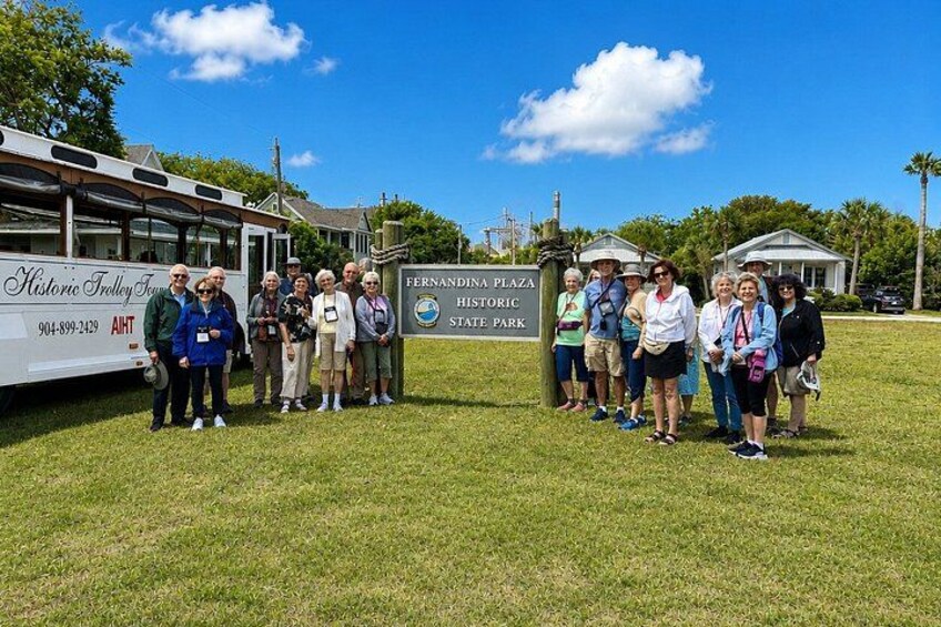 A group of people standing in front of a sign for Fernandina Plaza Historic State Park. 2